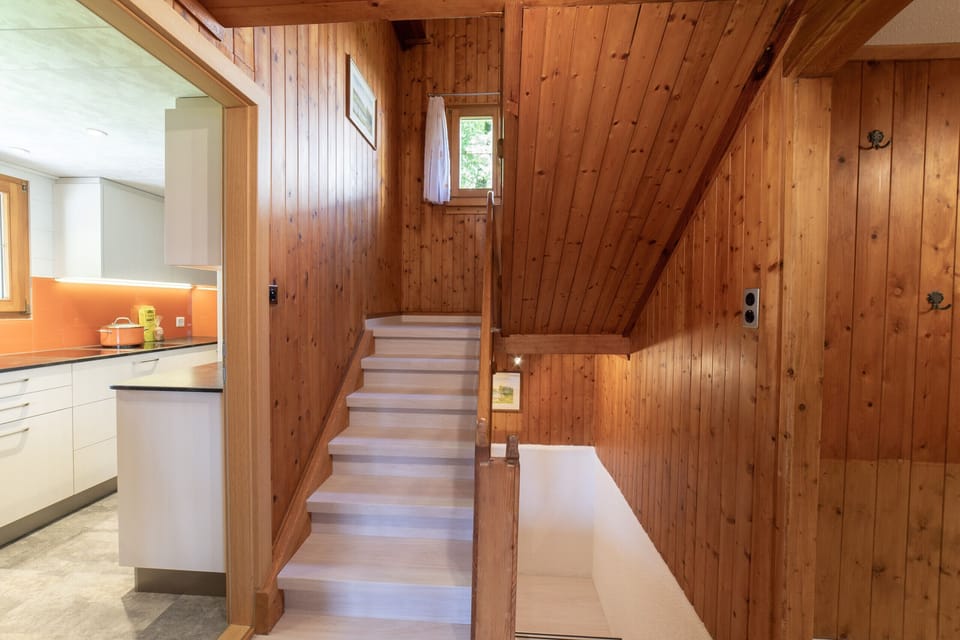 Wood-panelled hallway with stairs and access to the kitchen