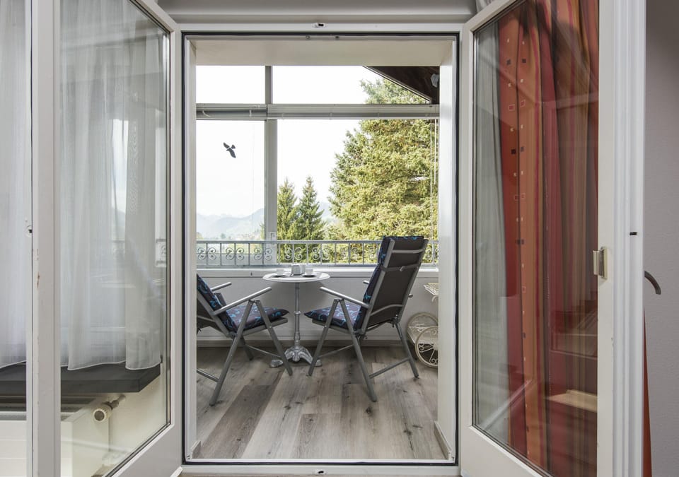 Open balcony door with a view of the furnished balcony