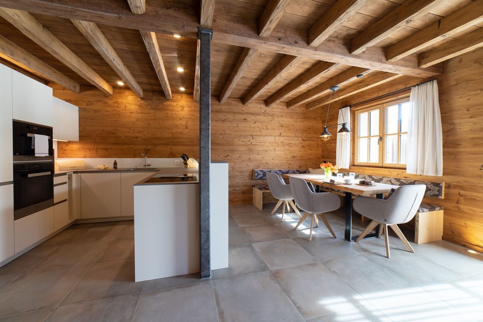 Open-plan kitchen with a cosy dining area in the wooden chalet
