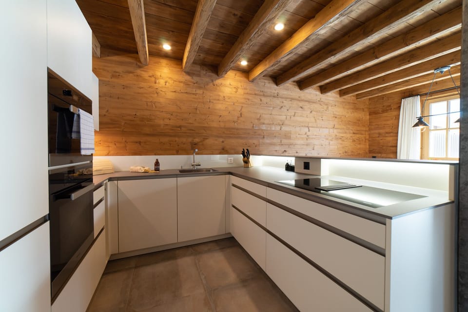 Modern kitchen with a wooden ceiling and generous worktop space