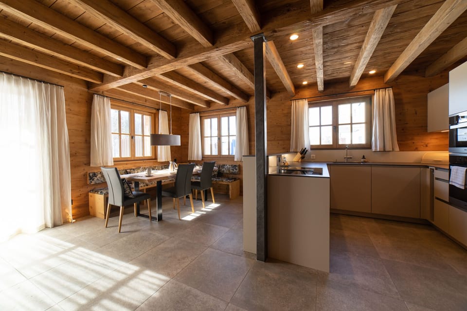 Open-plan kitchen with dining area and rustic wooden ceiling
