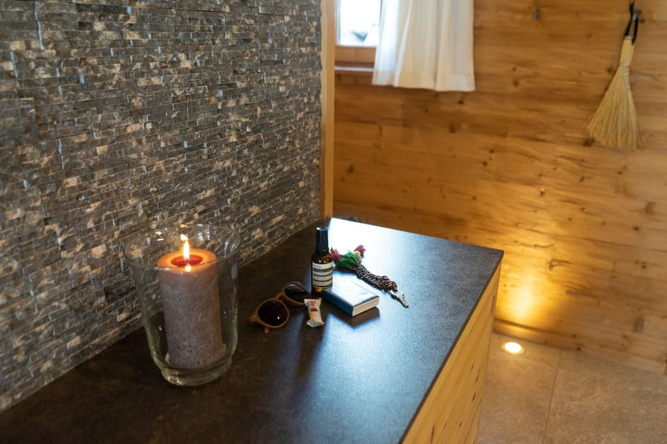 Decorative candle on a shelf in front of a natural stone wall