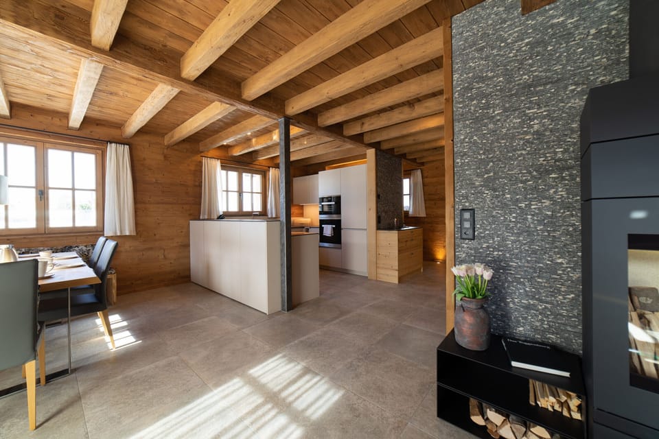 Open-plan kitchen and dining area with a wooden ceiling and a fireplace