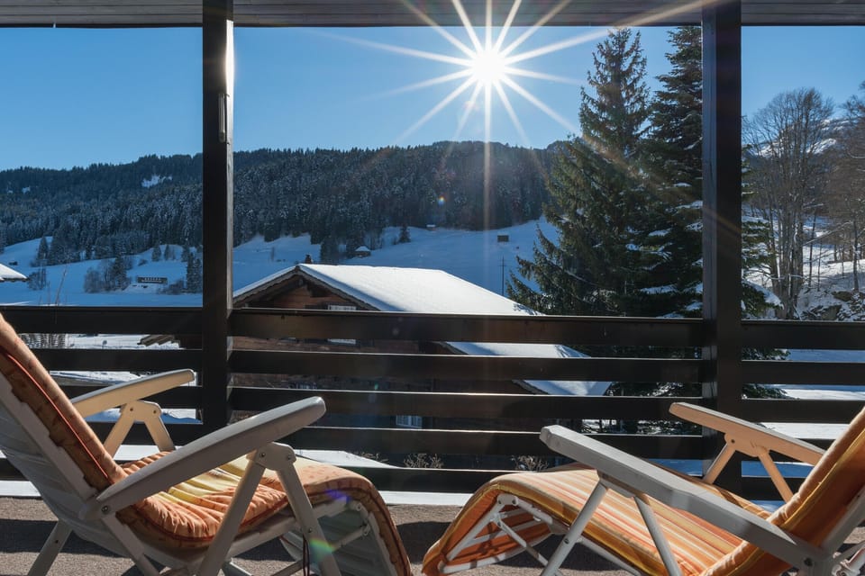 Sunny balcony with loungers and snowy views