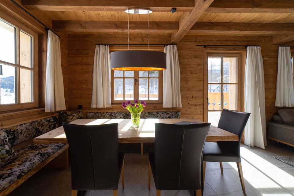 Dining area with wooden table, corner bench and dark chairs