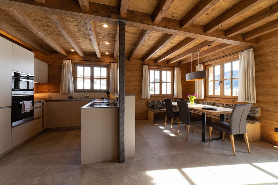 Open kitchen with dining area and exposed wooden beams