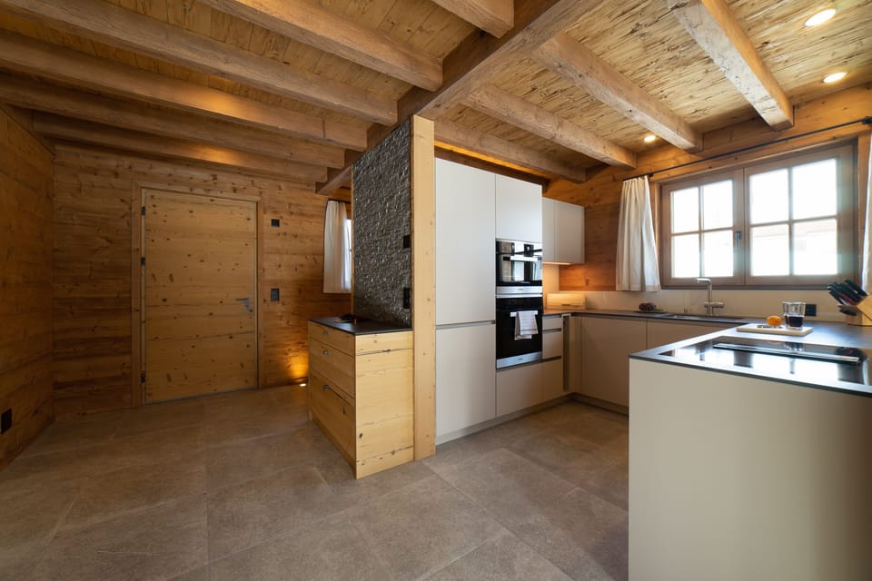 Modern kitchen with grey cabinets and exposed wooden beams