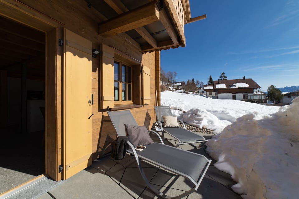 Sunny terrace at the wooden chalet with sun loungers