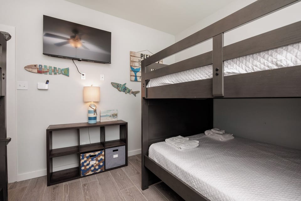 Your kids will love this fun bunk bed setup with entertainment and storage space for all their vacation treasures.