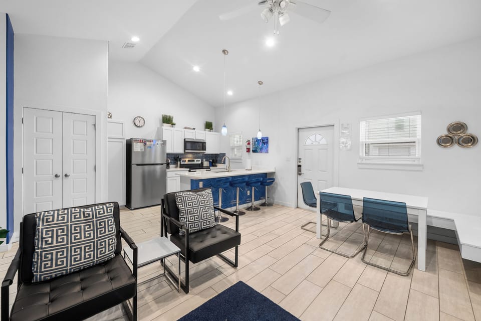 Soaring ceilings and open-plan design create a bright, airy atmosphere perfect for gathering with family or friends around the full kitchen and dining space.