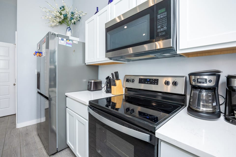 Your fully equipped kitchen awaits with stainless steel appliances, white cabinets, and everything you need to prepare delicious meals during your stay.