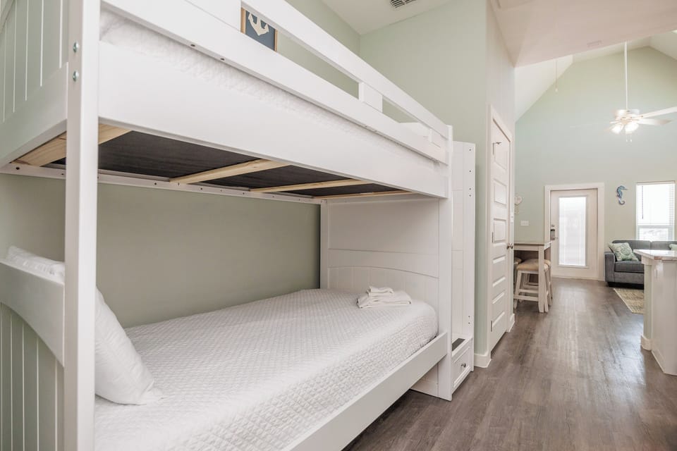 Relax in your stylish bunk bed sanctuary with crisp linens and coastal charm flowing into the bright living area.