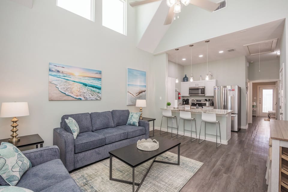 Relax in your bright, open living space with soaring ceilings and coastal artwork welcoming you home.