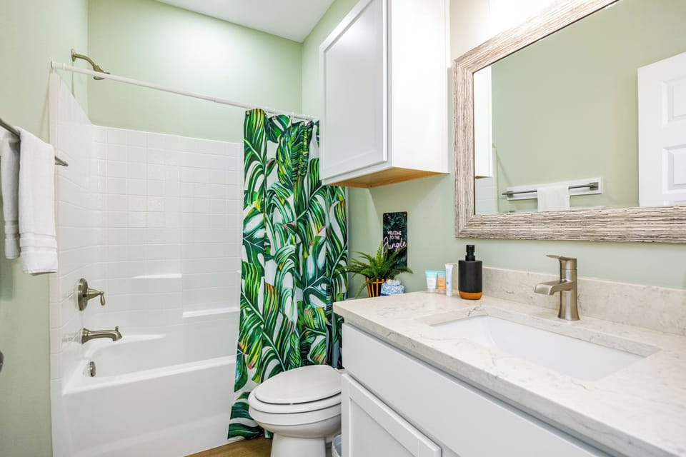 Refresh in your private bathroom featuring a spa-inspired palette, tropical touches, and modern marble vanity.