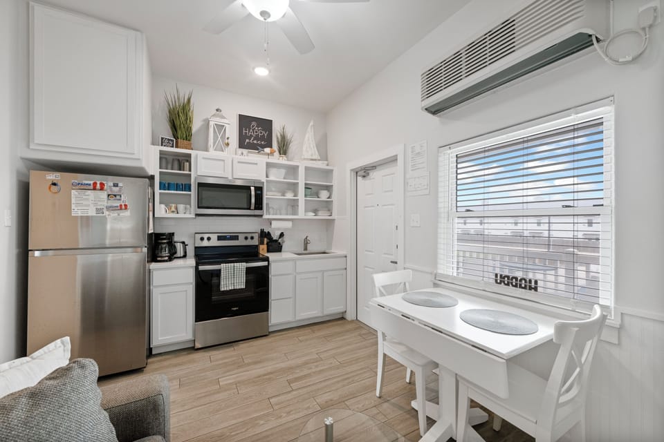 Your bright, fully-equipped kitchen invites you to prepare meals with modern appliances and ample storage in this stylish white space.