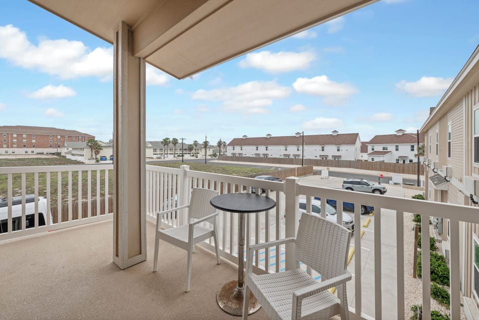 Relax on your private balcony with morning coffee at the bistro table, enjoying the peaceful neighborhood views.