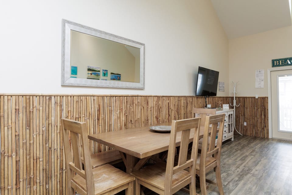 Gather around your spacious dining table with beach-themed decor and bamboo accents creating a relaxed coastal atmosphere.