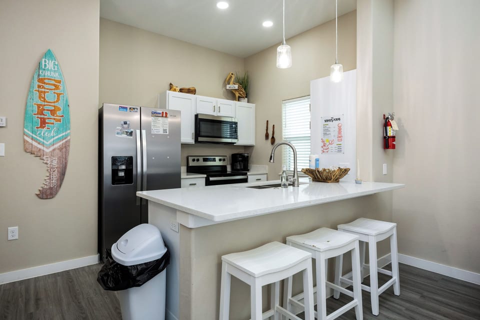 Your fully equipped kitchen awaits with modern appliances, quartz countertops, and casual breakfast bar seating for morning coffee.