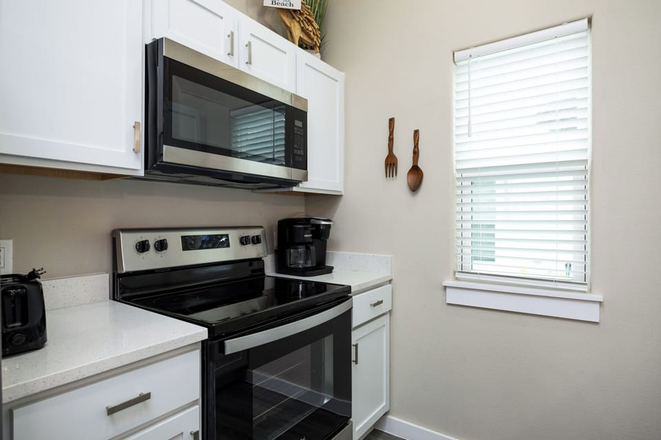 Your bright, fully-equipped kitchen awaits with modern appliances and charming coastal touches, perfect for preparing meals during your stay.