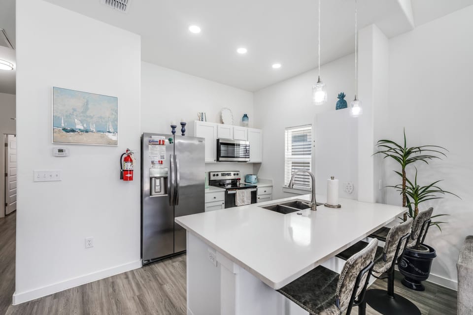 Your modern kitchen welcomes you with sparkling quartz countertops, stainless steel appliances, and elegant pendant lights creating the perfect space for memorable meals.