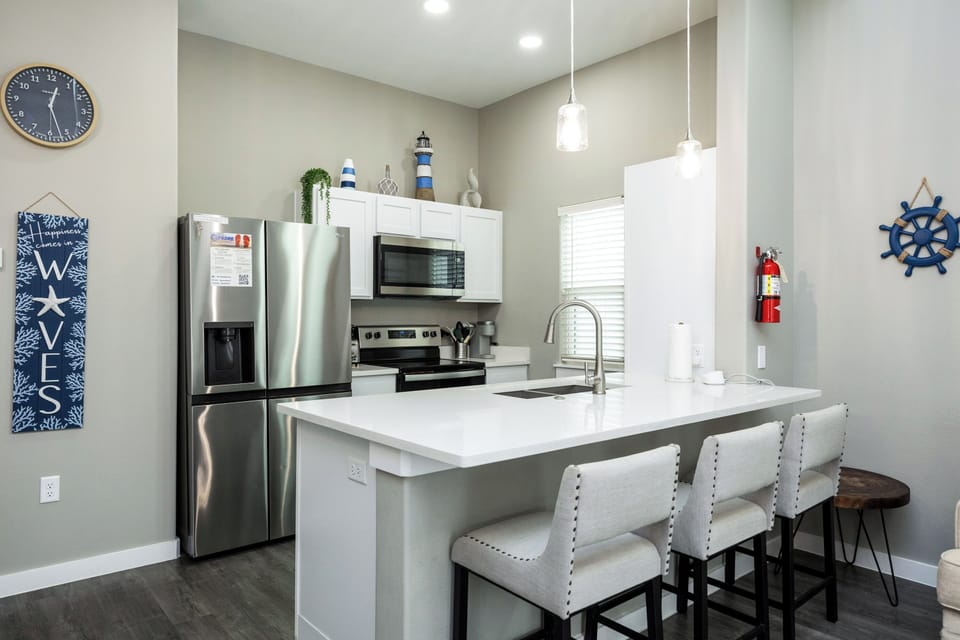 Gather around your bright modern kitchen with gleaming granite counters, stylish pendant lighting, and comfortable bar seating perfect for morning coffee or evening conversations.