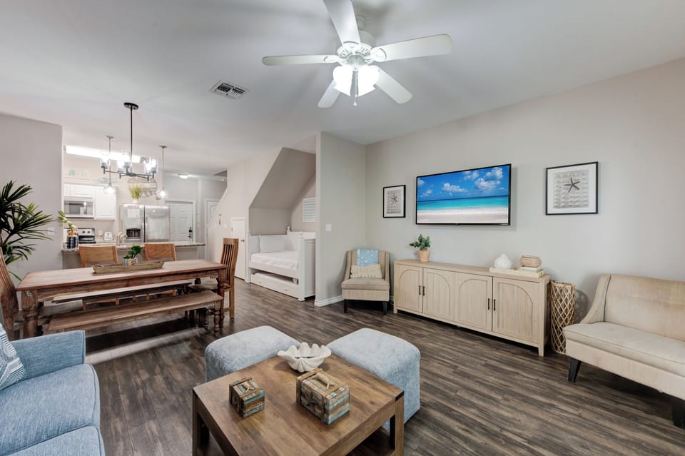 Relax in your spacious, coastal-themed living area with comfortable seating, modern furnishings, and an open layout perfect for unwinding.