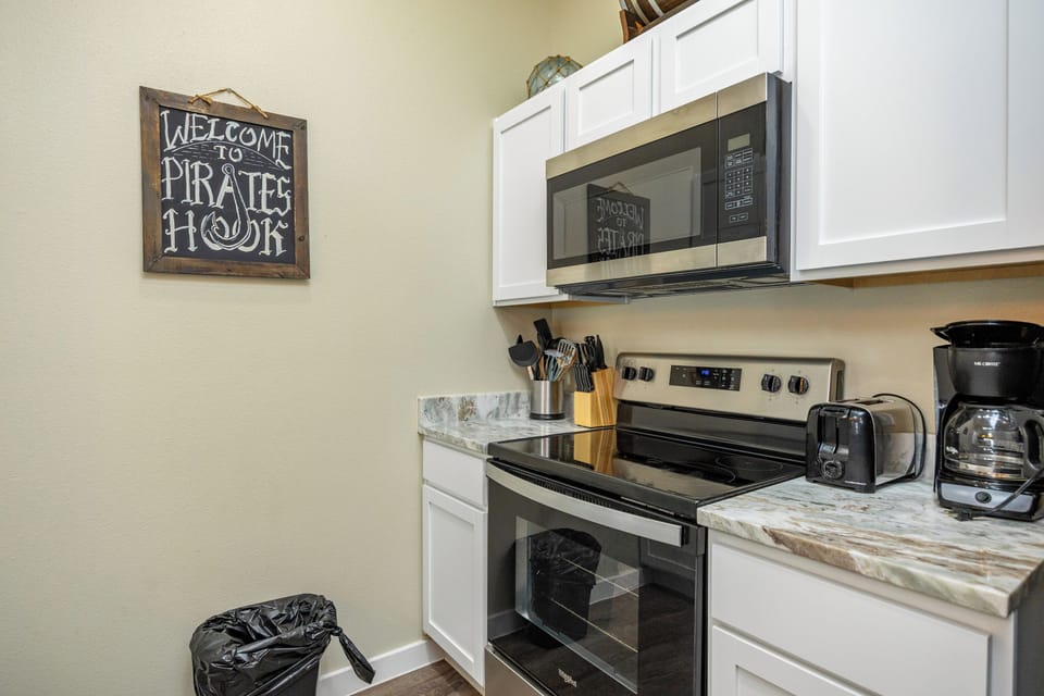 Your fully equipped kitchen features modern appliances and charming pirate-themed decor, making meal prep feel like a fun adventure.