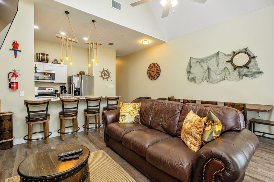 Sink into the rich leather sofa while nautical decor surrounds you in this coastal-themed living space, complete with modern kitchen.