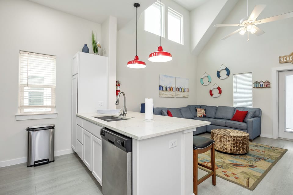 Your bright beach-themed haven features a modern kitchen island perfect for morning coffee and an inviting living space with coastal charm.
