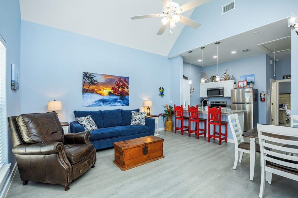 Relax in your coastal-themed living space with comfortable seating and an open kitchen, perfect for gathering with family and friends.