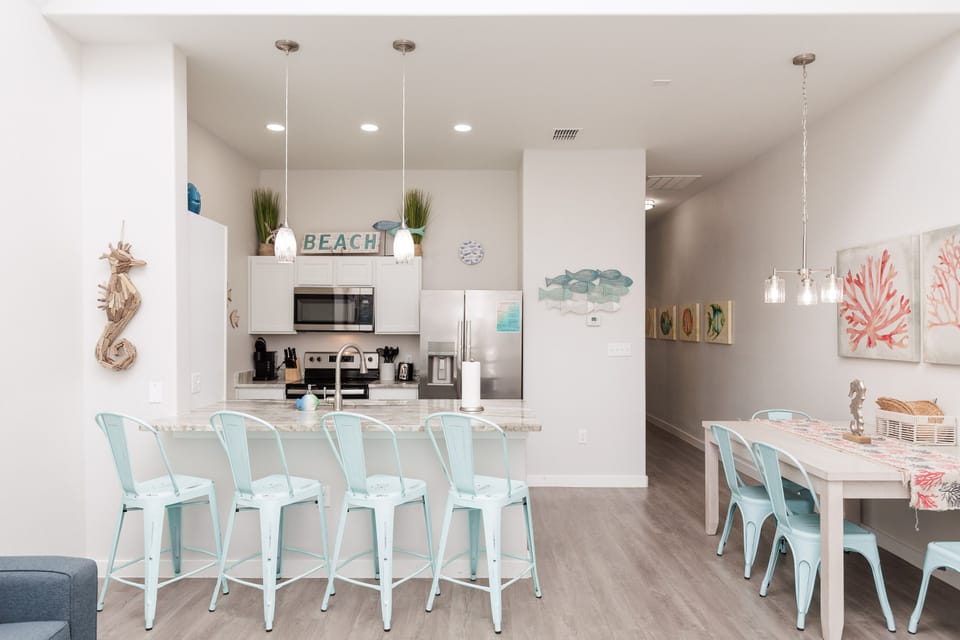 Gather around your coastal-inspired kitchen with mint bar stools and dining space, perfect for morning coffee and evening meals together.
