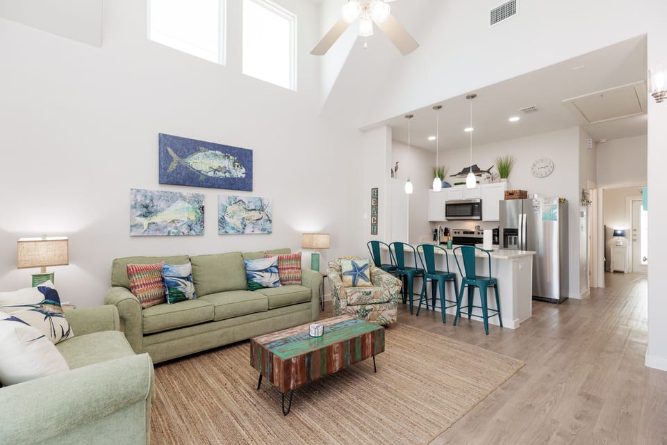 Relax in your bright coastal-themed living space with vaulted ceilings and modern kitchen where you'll love gathering for meals.