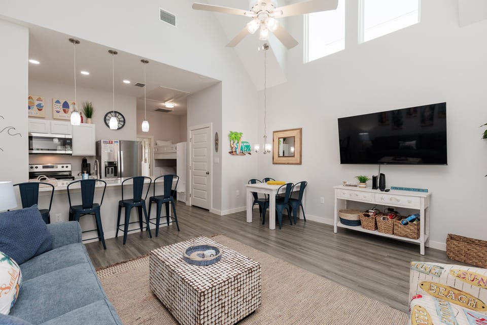 Unwind in your bright, open-plan living space with soaring ceilings, modern kitchen, and comfortable seating perfect for relaxing together.