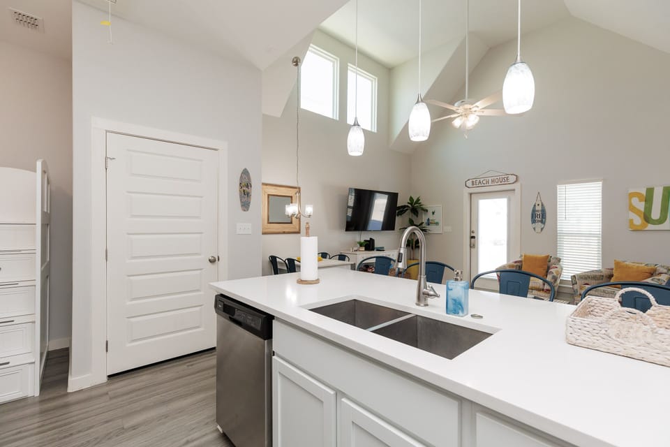 Your bright kitchen island becomes the heart of beach memories, with gleaming countertops and modern appliances ready for coastal gatherings.