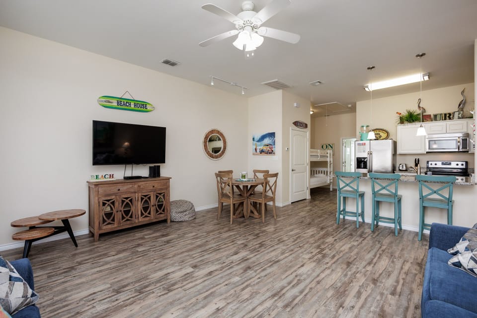 Your beach-themed retreat features an open living space with turquoise bar stools and coastal charm throughout every detail.