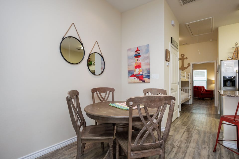 Gather around your charming dining table for meals and conversation, with coastal artwork adding seaside charm to your home away from home.