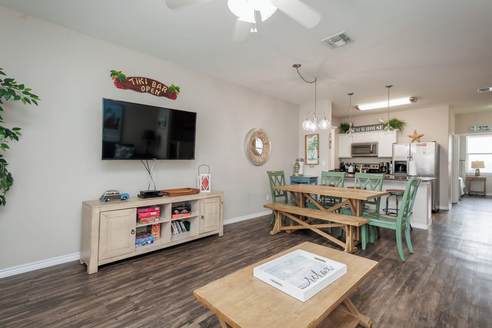 Gather in your bright open-plan living space with tropical touches, flat-screen TV, and cheerful dining area perfect for meals together.