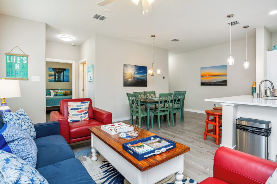 Relax in your vibrant living space where coastal blues meet cheerful reds, complete with modern kitchen and dining for memorable gatherings.