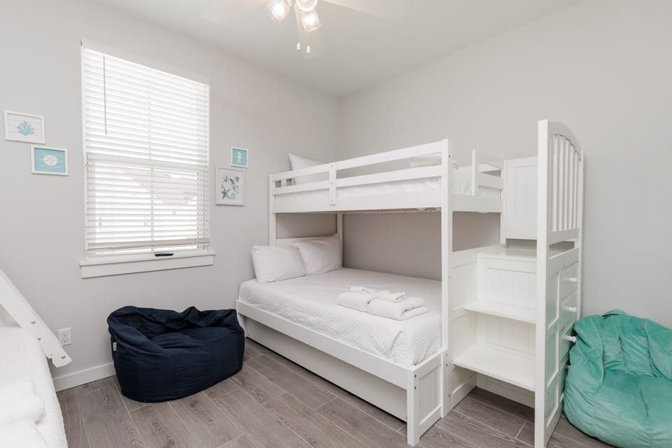 Your kids will love this bright, cheerful bedroom with two sets of twin over full bunk beds, fun bean bag seating, and coastal artwork creating the perfect sleepover atmosphere.