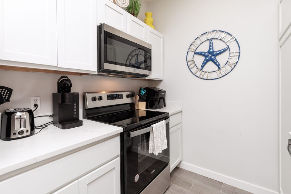 Your fully equipped kitchen makes meal prep a breeze with modern appliances and coastal charm.