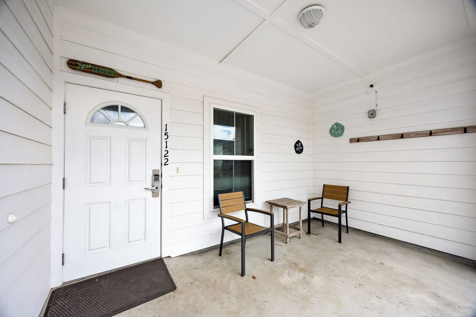 Entryway with coded lock for added security and covered porch where comfortable seating awaits for morning coffee or evening relaxation.