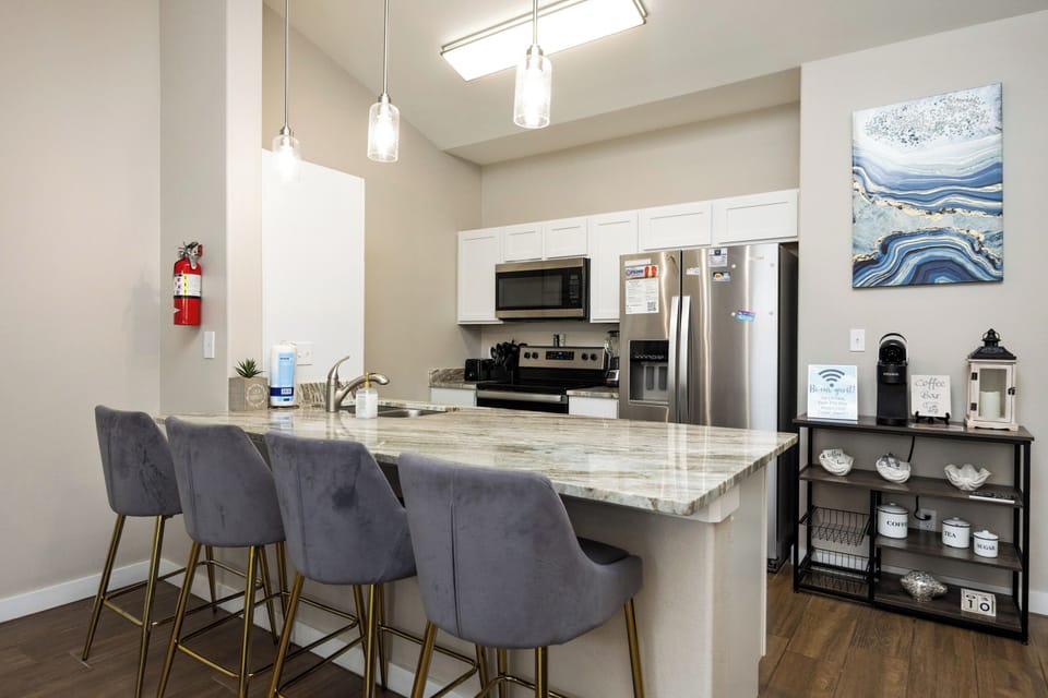 Your modern kitchen awaits with sleek granite counters, stainless appliances, and stylish seating perfect for morning coffee or casual meals.