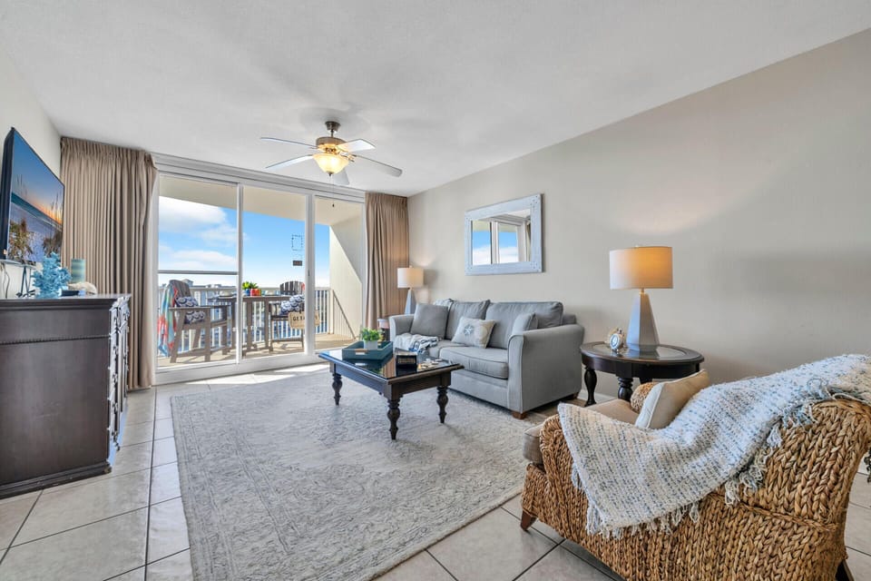 Relax in your bright living room with comfortable seating and expansive windows showcasing water views.