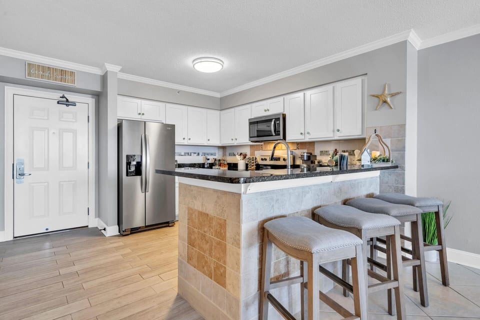 You'll love preparing meals in this fully equipped kitchen featuring granite countertops, stainless steel appliances, and a convenient breakfast bar for four.