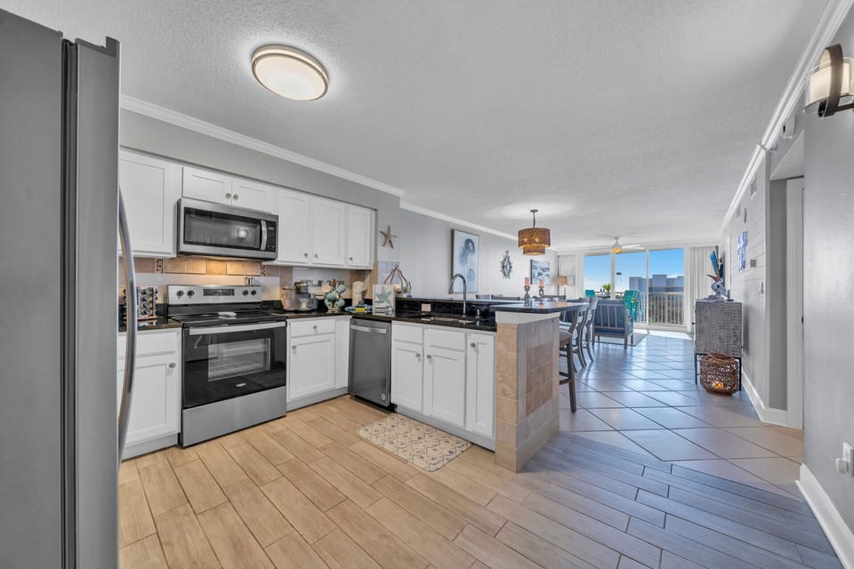 Your fully-equipped kitchen features modern appliances and flows seamlessly into the bright dining area with stunning views beyond.
