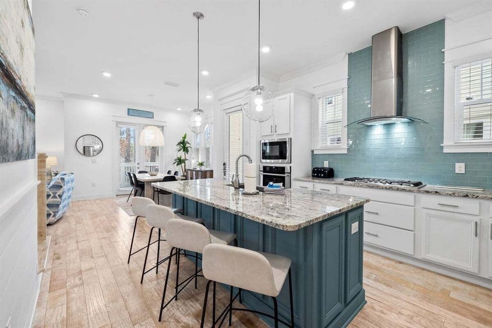 This stylish kitchen boasts a spacious island, top-of-the-line appliances, and a sleek backsplash for an elevated cooking experience.