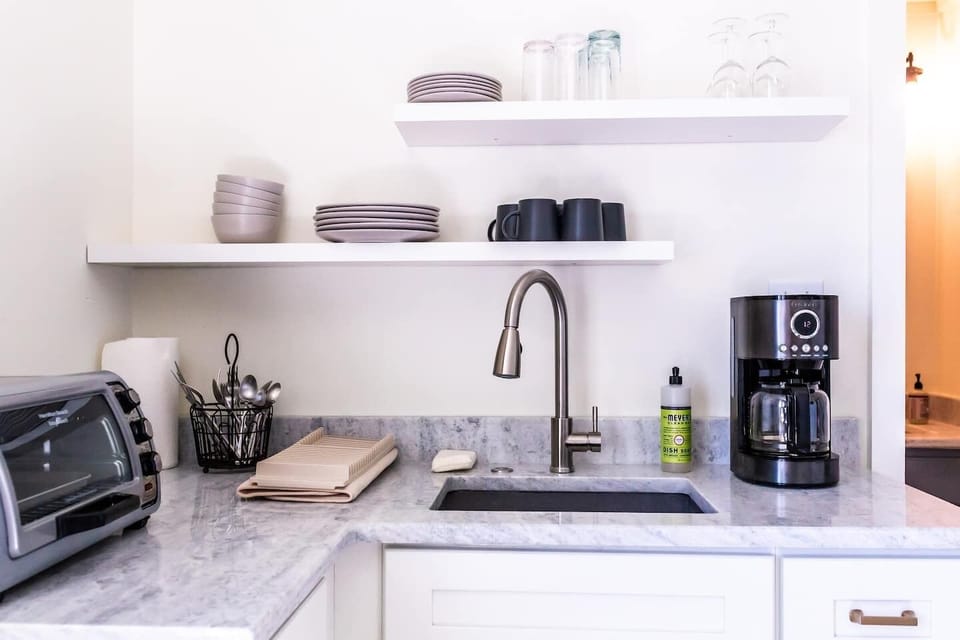 Toaster oven, coffee maker, microwave, and refrigerator all available in this kitchenette