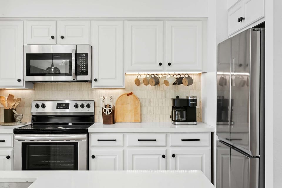 Fully-stocked kitchen with stainless steel appliances and island with barstool seating for four