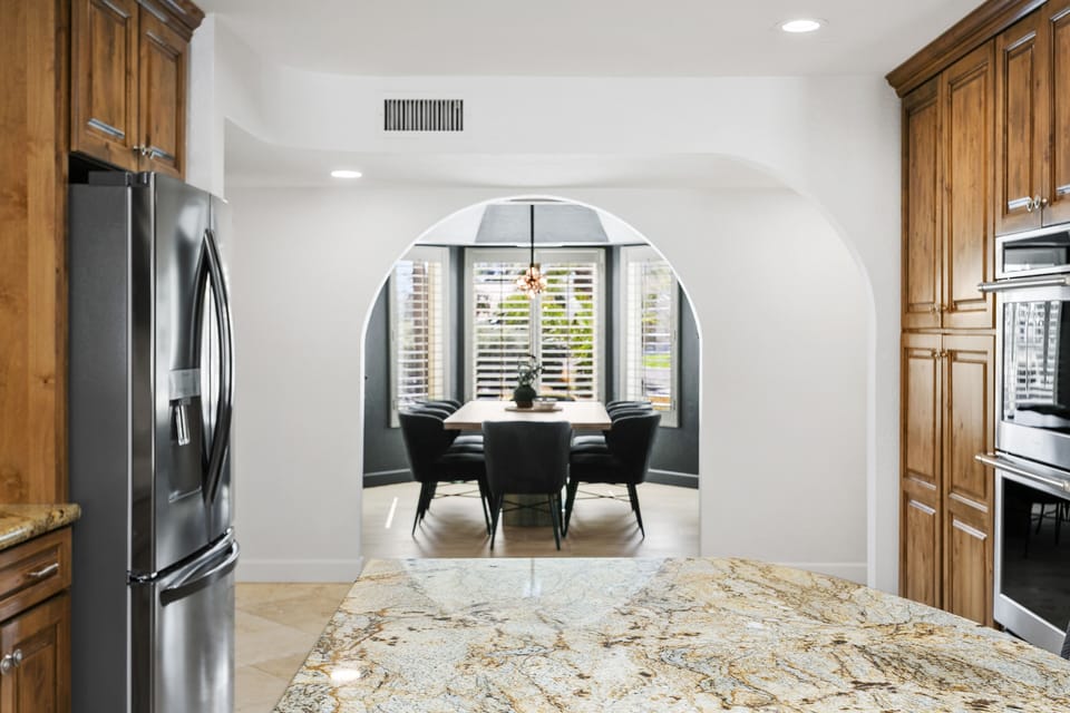 Elegant dining room for 8, adorned with ambient lighting and striking black walls