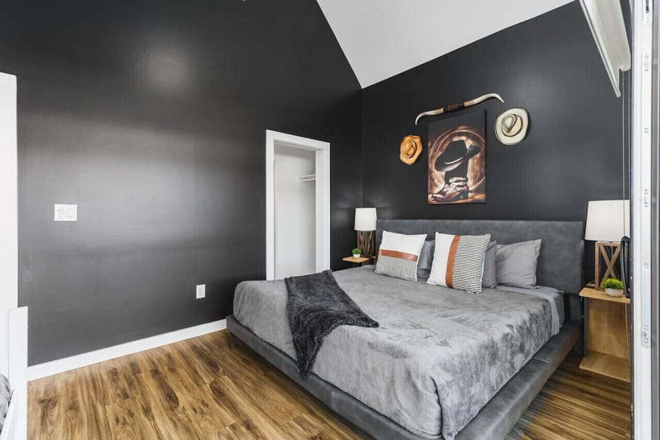 Upstairs bedroom #3 with a King bed, twin + trundle bed, and large sunny patio space with outdoor furniture & cornhole.